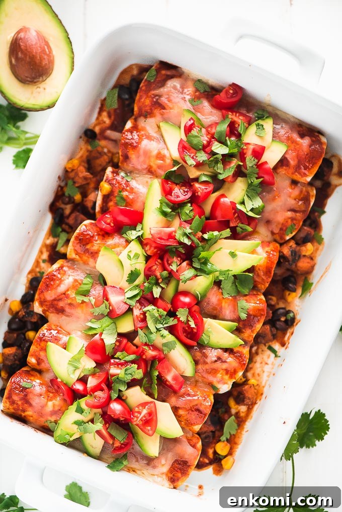 Baked enchiladas Birds eye view of a casserole dish full of Black Bean and Sweet Potato Enchiladas topped with melted cheese, avocado slices, and diced tomatoes.