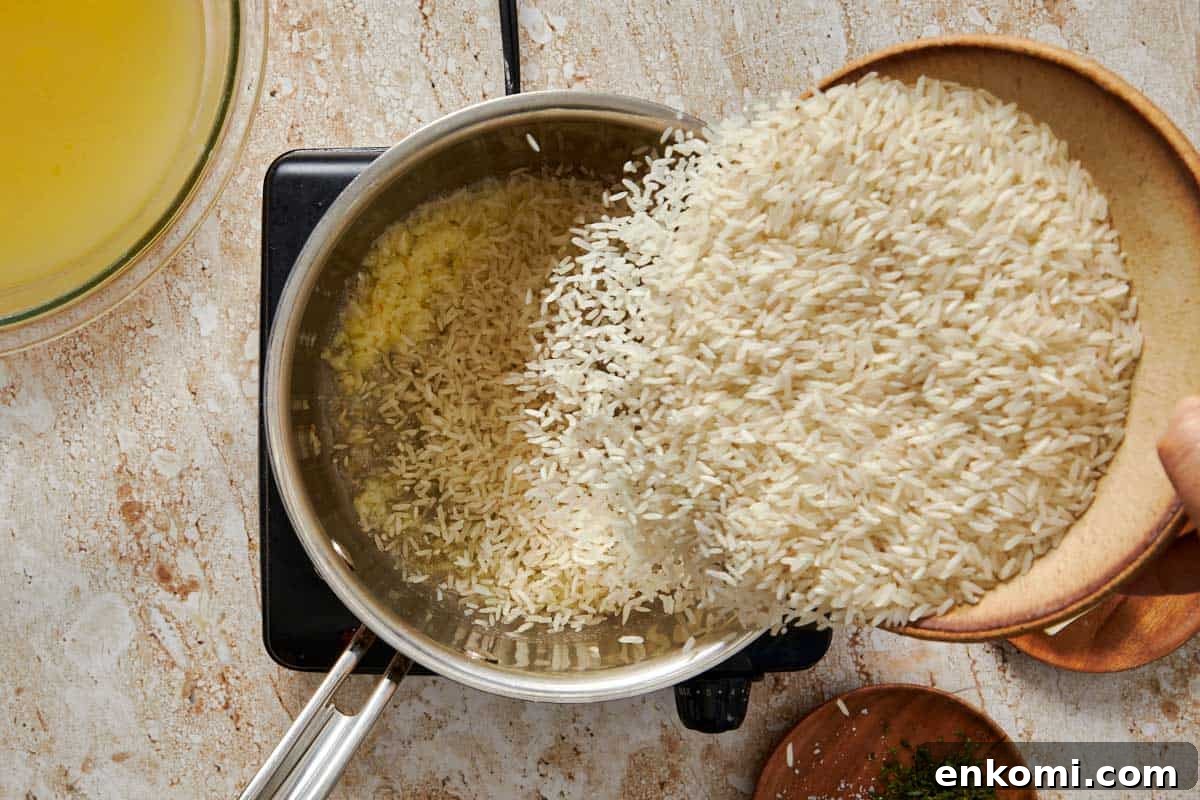 Garlic Butter Rice Recipe: Fluffy, Flavorful Side Dish 5 pot on a stove with garlic and butter being saute'd and melted having rice poured in