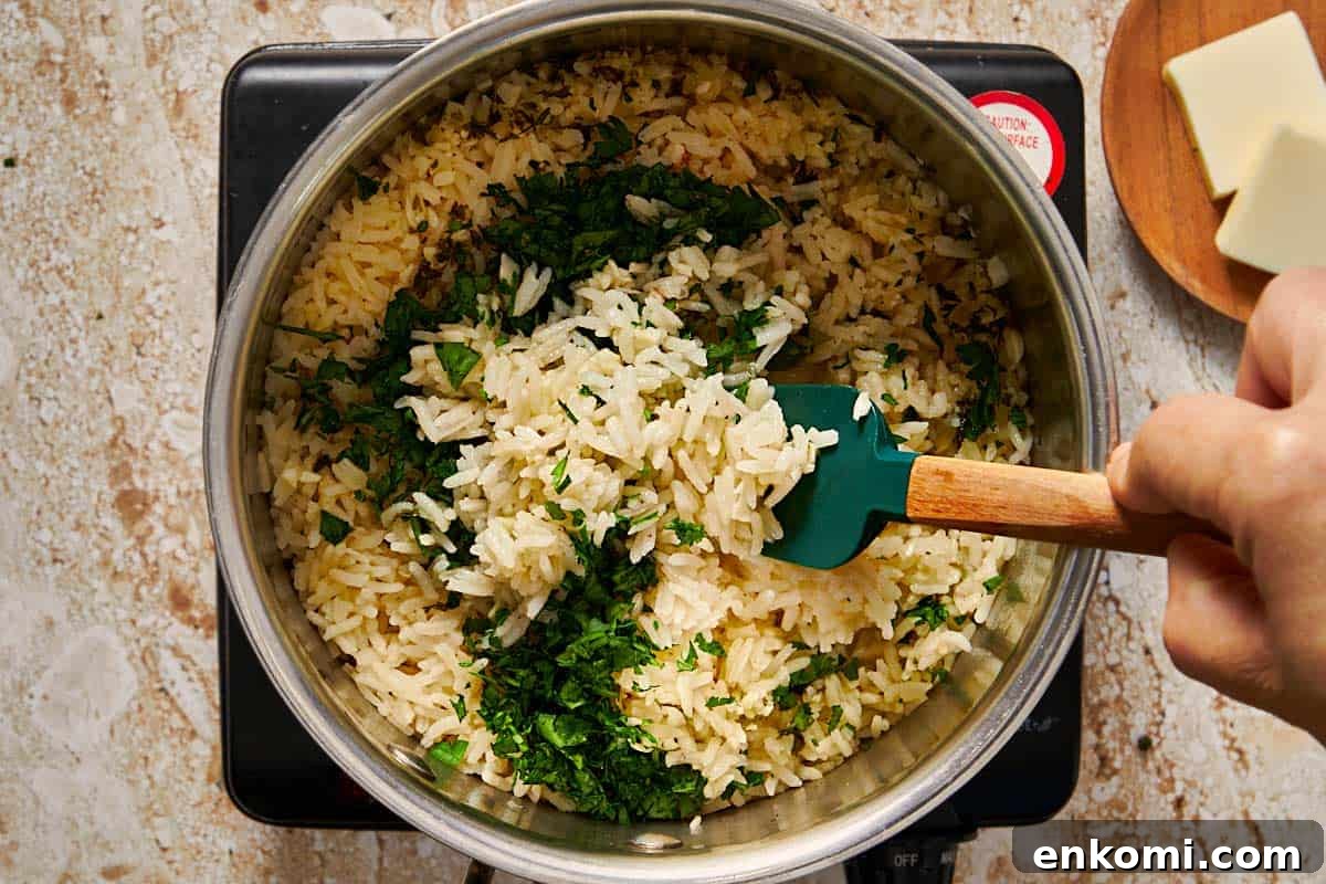 Garlic Butter Rice Recipe: Fluffy, Flavorful Side Dish 8 rice being cooked in a pot having fresh parsley poured in