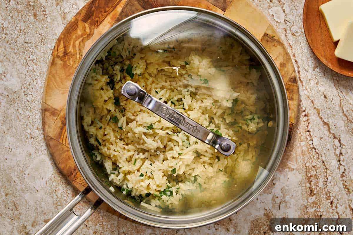 Garlic Butter Rice Recipe: Fluffy, Flavorful Side Dish 9 rice being cooked in a pot with a lid