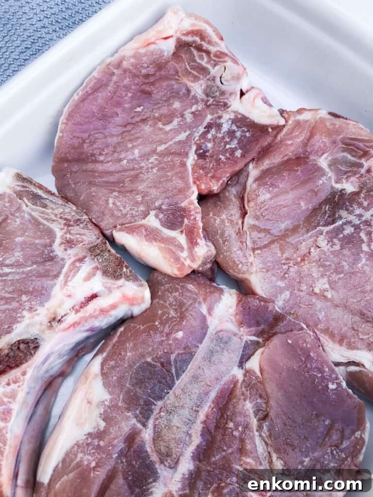 Honey Dijon Pork Chops: Sous Vide, Grill, or Oven Roast 2 Raw pork chops in a baking dish.
