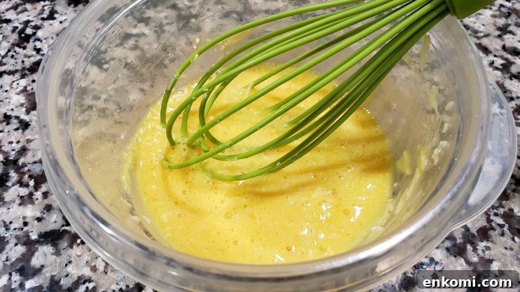 egg and parmesan whisked together in a bowl.