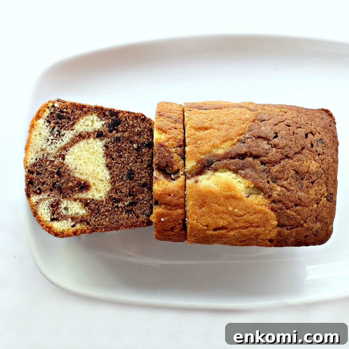 Marbled loaf on a white platter with one cut slice showing the marbled pattern inside.