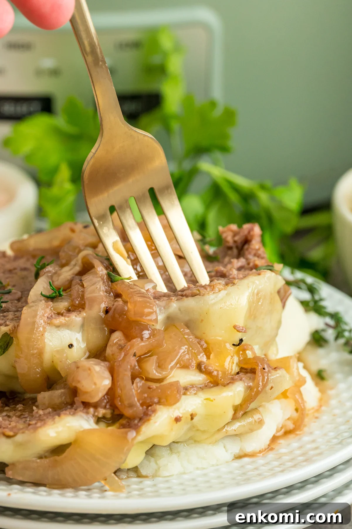 French Onion Meatloaf with Caramelized Onions and Gruyère 2 Slow cooker french onion meatloaf on a plate with a fork taking some.
