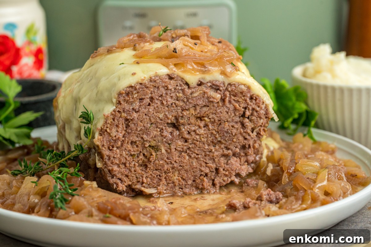 French Onion Meatloaf with Caramelized Onions and Gruyère 6 Open slow cooker french onion meatloaf on a serving plate.
