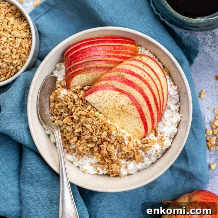 Overhead view of a breakfast table with a bowl full of cottage cheese and apple with granola and cinnamon.