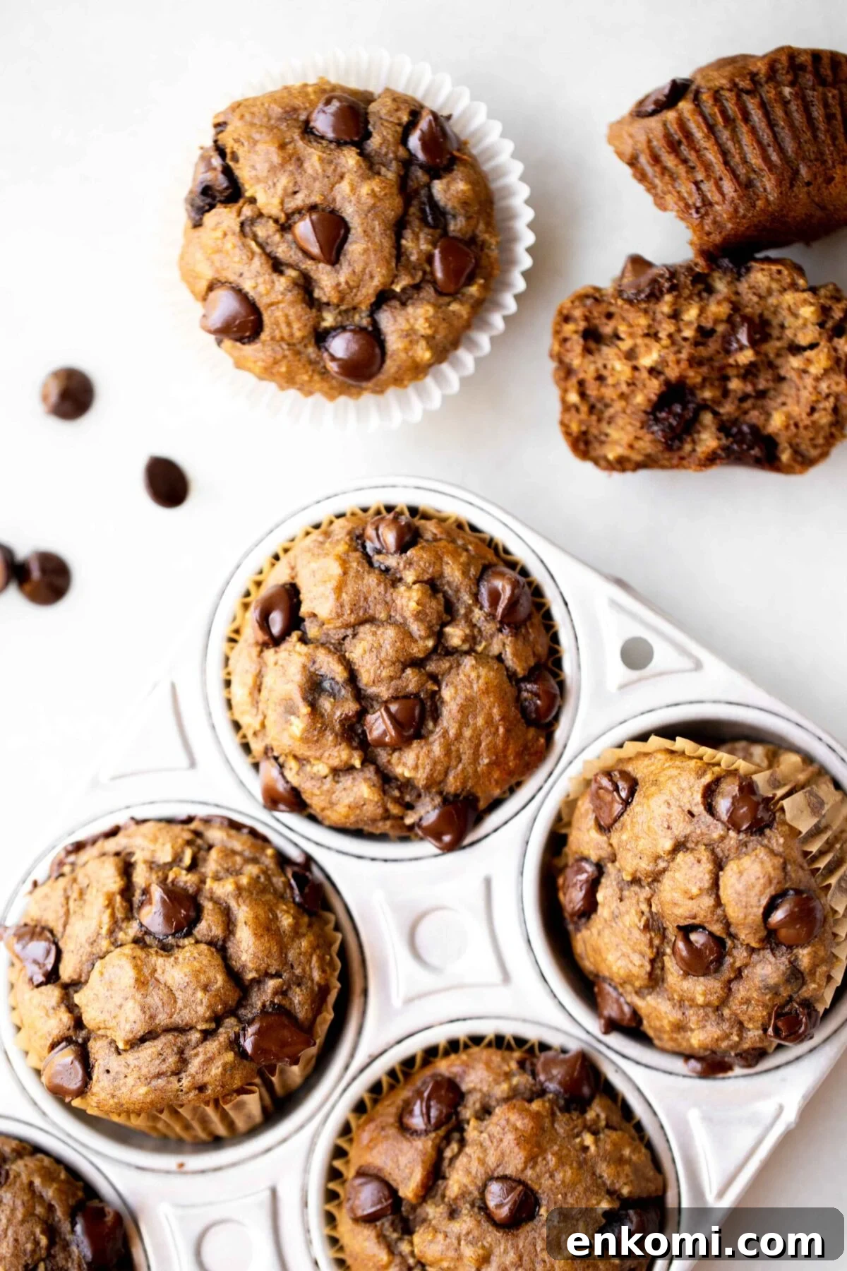 Banana Lentil Muffins with Oats — Protein-Packed Snack Recipe 2 overhead photo of freshly baked healthy muffins, chocolate chip banana muffins, in an aluminum muffin pan with milk and chocolate chips in the background