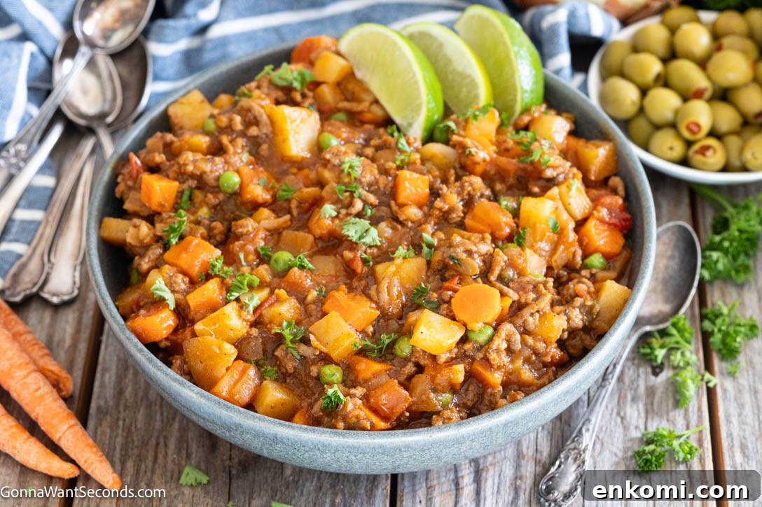 Mexican Picadillo is a cozy, hearty skillet meal with ground beef, potatoes, carrots, and tomatoes. It's simple, affordable, and perfect for busy family dinners. #mexicanfood #picadillo Mexican style picadillo in a bowl garnished with sliced lime