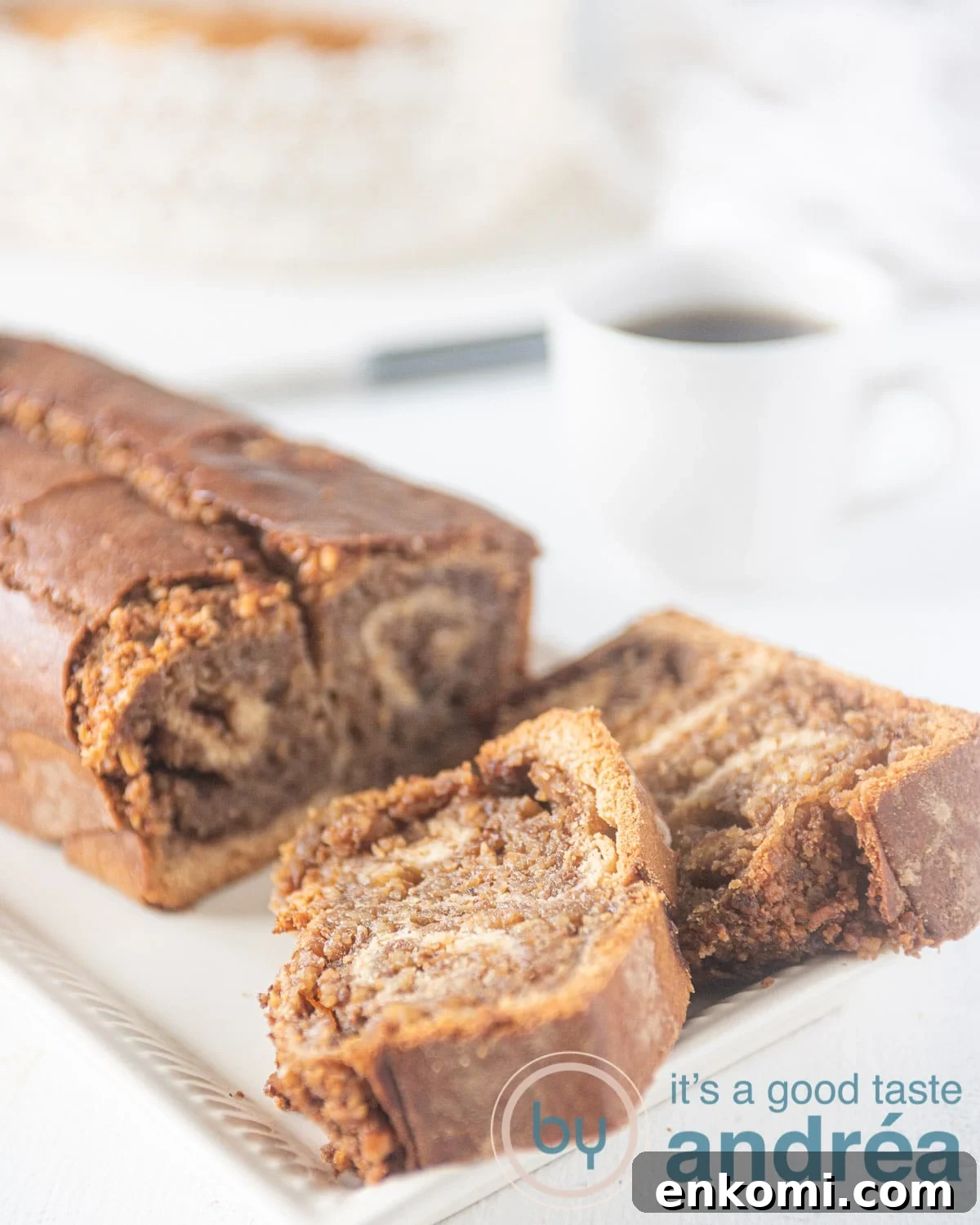 Povitica on a cake stand. Two slices are cut off. You see a walnut swirl in the bread.
