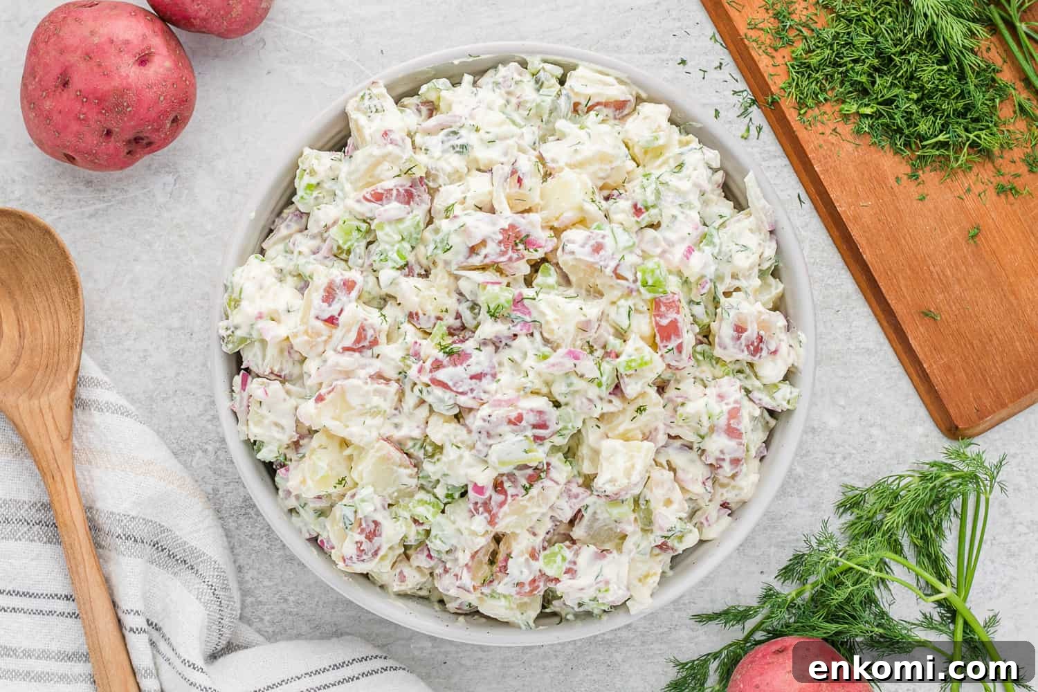 Creamy Dill Potato Salad with Fresh Herbs & Lemon Zest 9 Dill pickle potato salad in a white serving bowl.