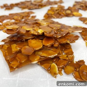 Stacked almond nougatine pieces on parchment paper.