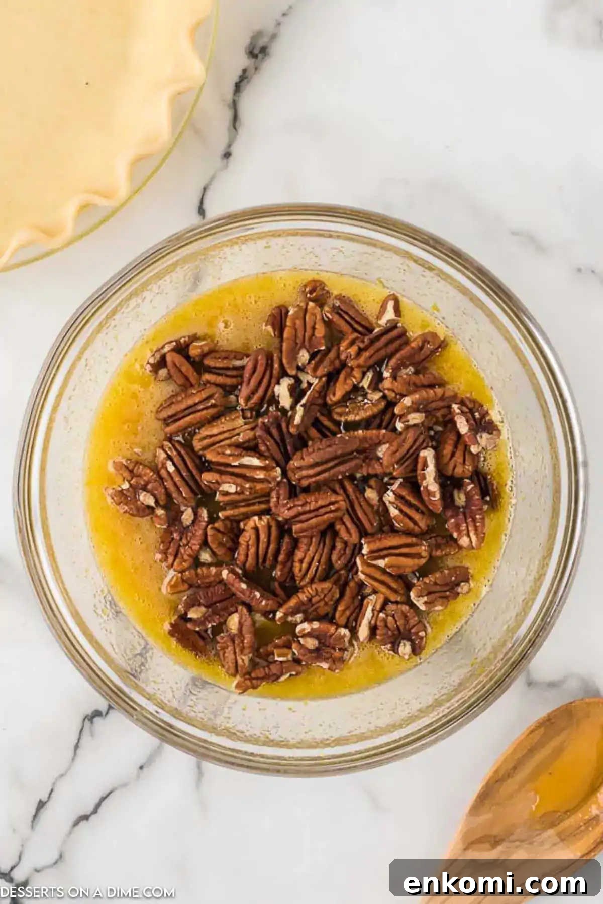 Pecans added to mixing bowl with egg mixture. 