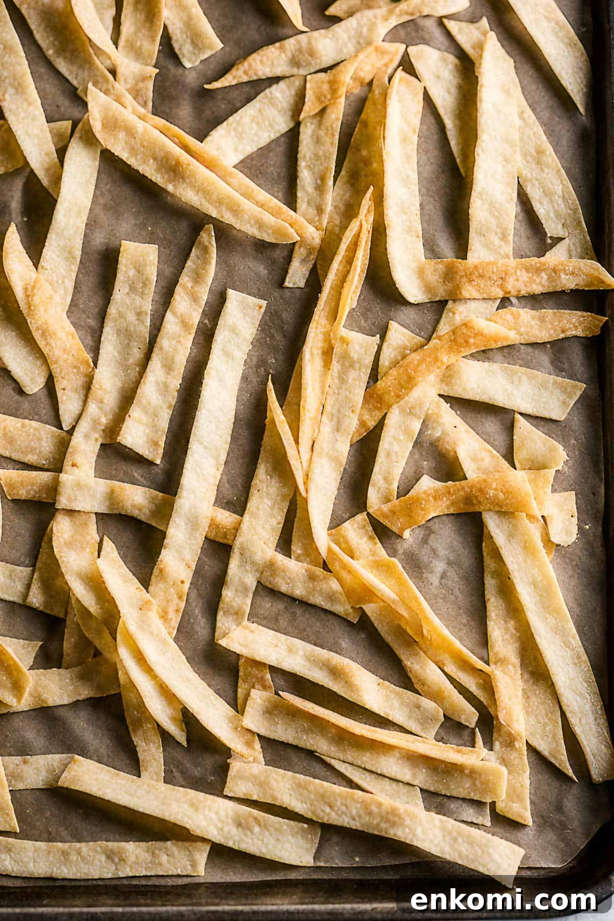 Baked tortilla strips on a baking sheet.