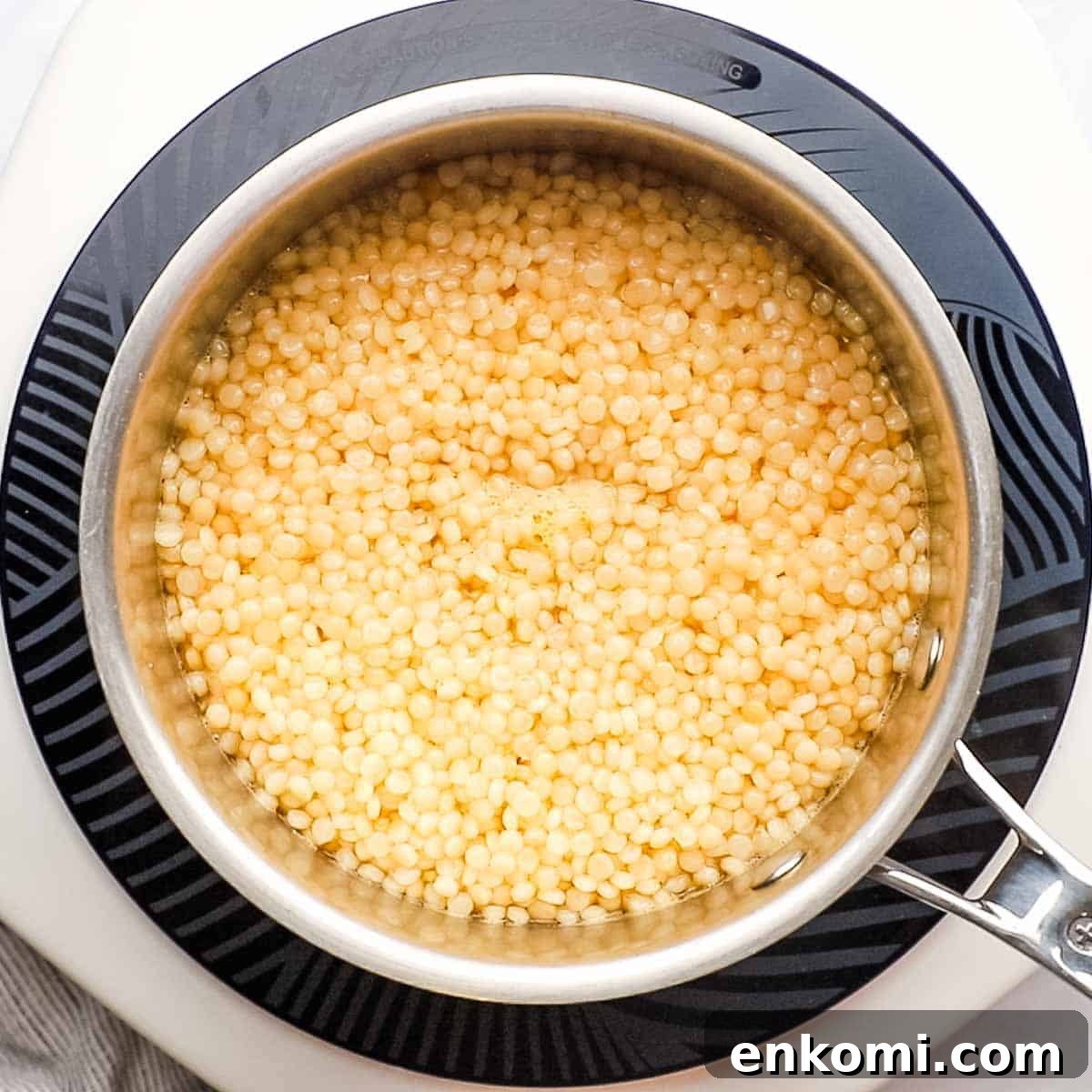 Mediterranean Pearl Couscous Salad with Fresh Herbs & Feta 7 Cooked Israeli couscous in a saucepan.