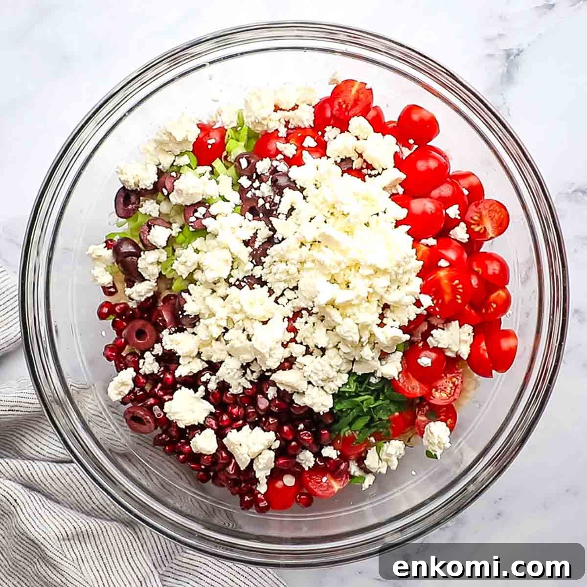 Mediterranean Pearl Couscous Salad with Fresh Herbs & Feta 9 Ingredients for a Mediterranean couscous salad in a large bowl.