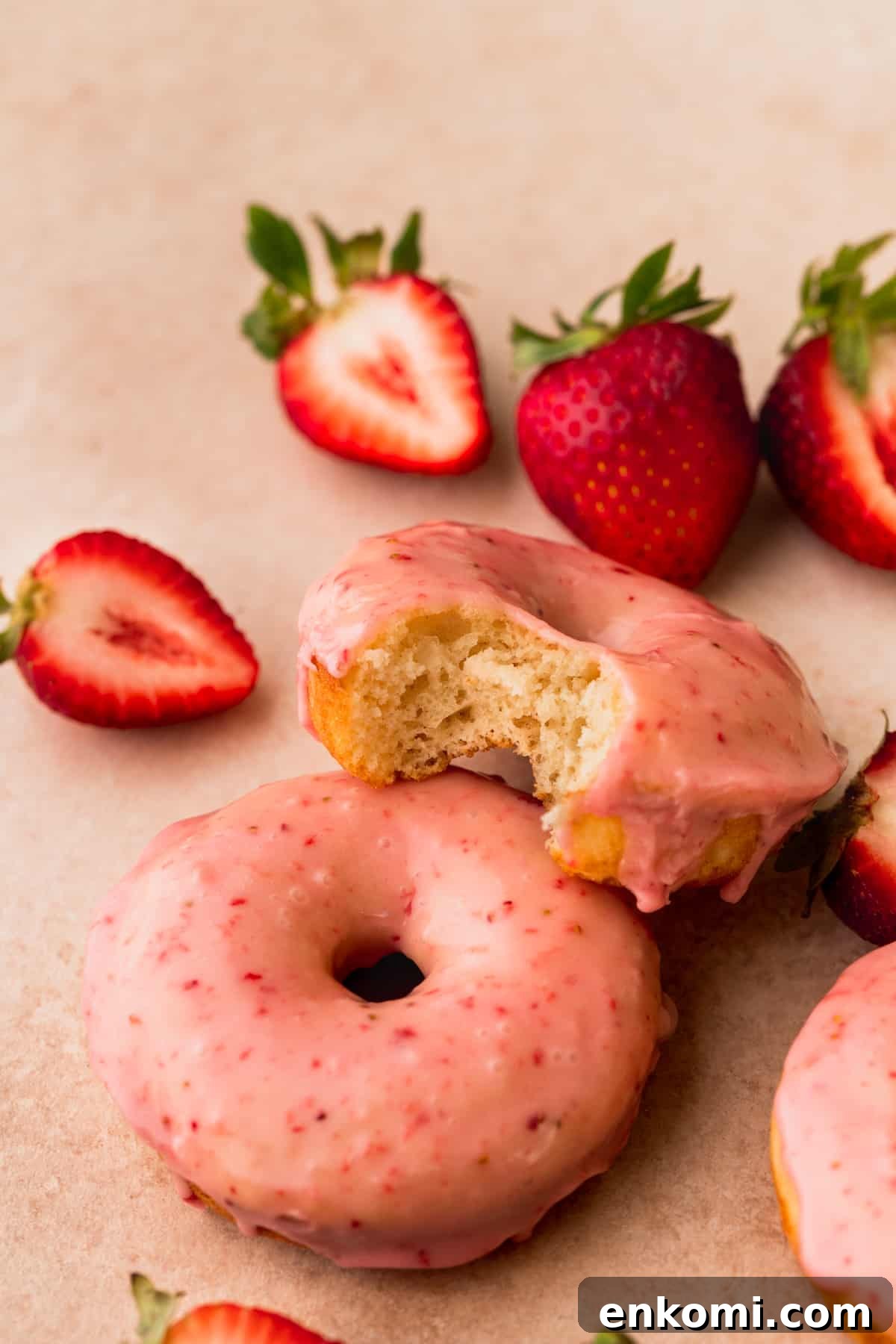 Bite missing from donuts on top of another donut.
