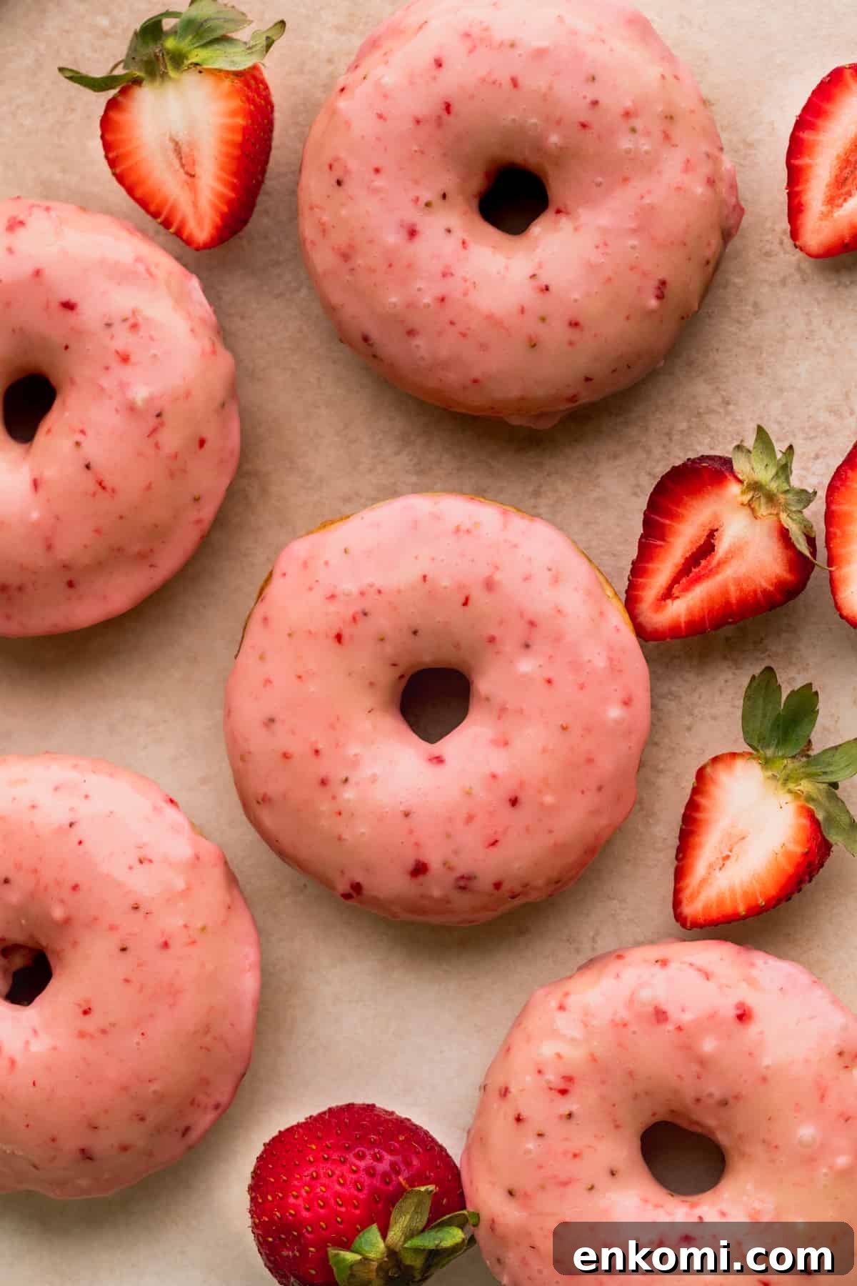 Strawberry glazed donuts laid out.
