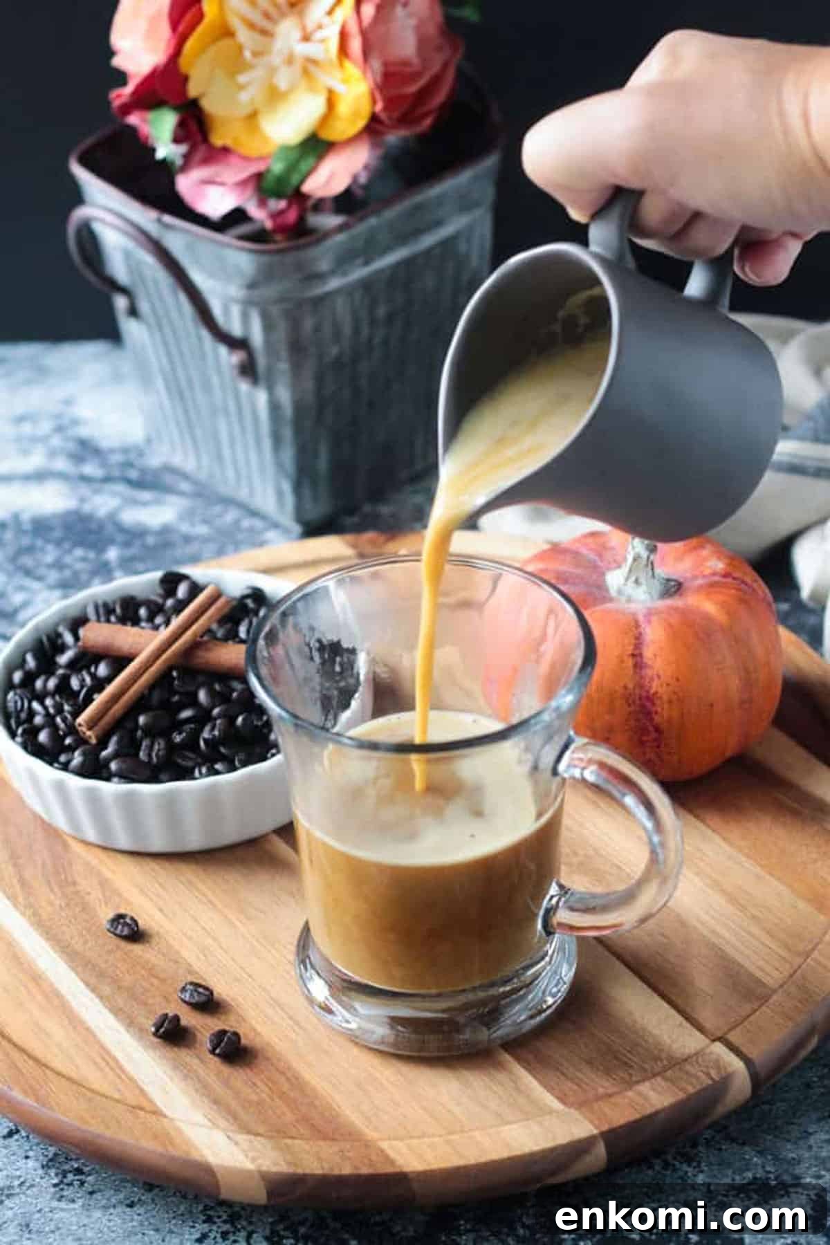 Harvest Oat Pumpkin Latte - a creamy, dairy free coffee drink perfect for sipping this fall. Made with real pumpkin and no refined sugar, this delicious beverage is a indulgent treat you can feel good about. Tastes like your favorite pumpkin spice latte! Latte being made by pouring the pumpkin milk into a glass of coffee.
