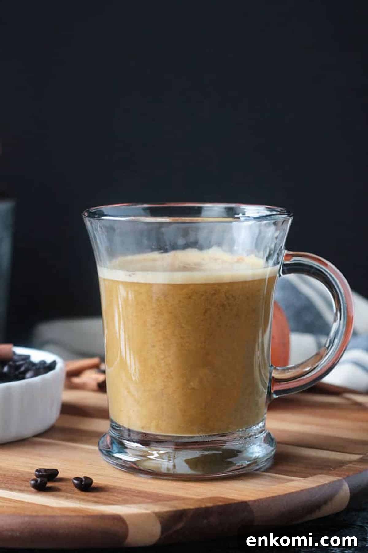 Harvest Oat Pumpkin Latte - a creamy, dairy free coffee drink perfect for sipping this fall. Made with real pumpkin and no refined sugar, this delicious beverage is a indulgent treat you can feel good about. Tastes like your favorite pumpkin spice latte! Creamy coffee drink in a clear glass with a handle.