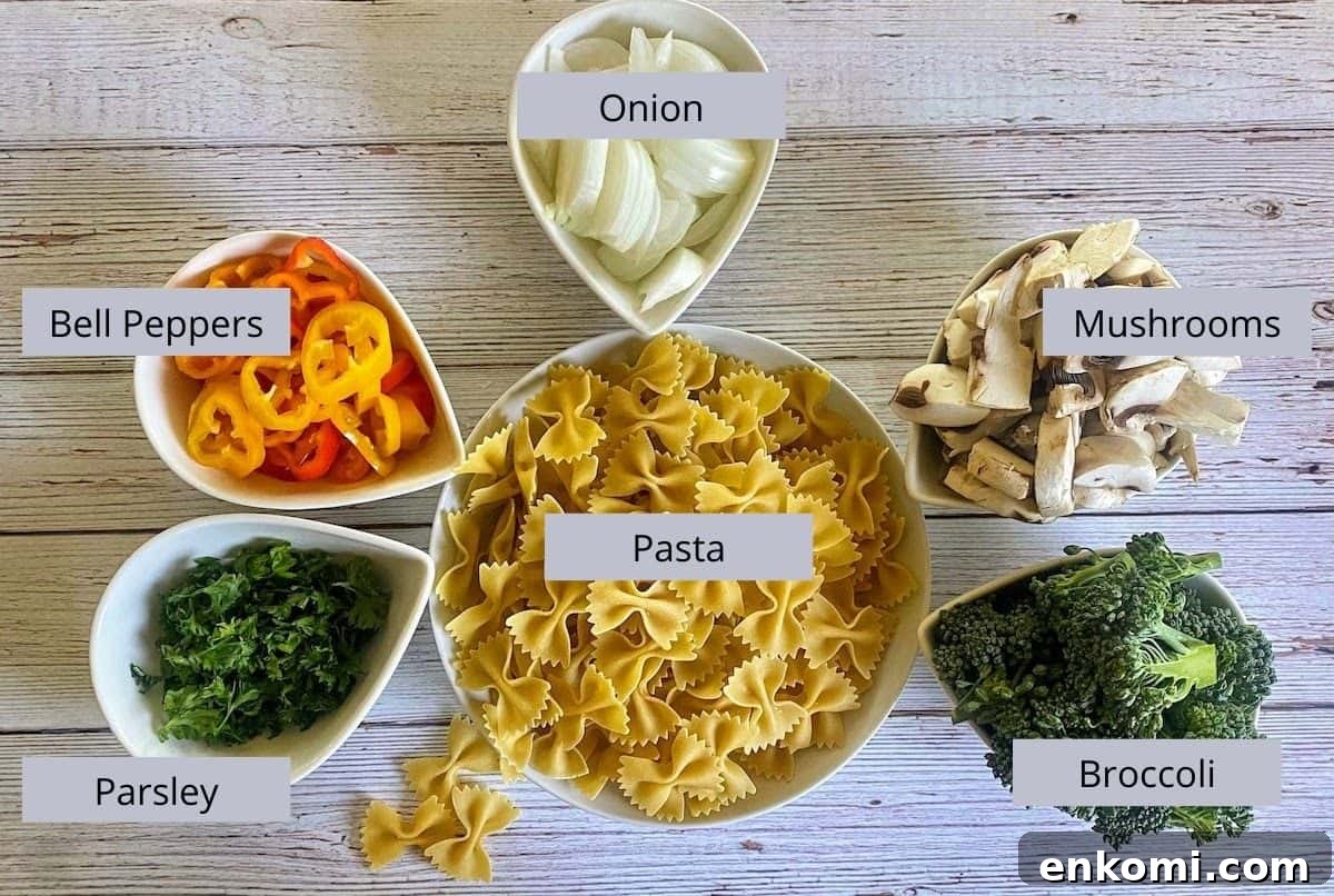 Chipotle mac and cheese ingredients: Onion, mushrooms, broccoli, pasta, parsley, and baby bell peppers in bowls on the counter.