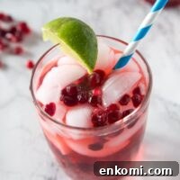 Pomegranate vodka gimlet in a cup with a straw
