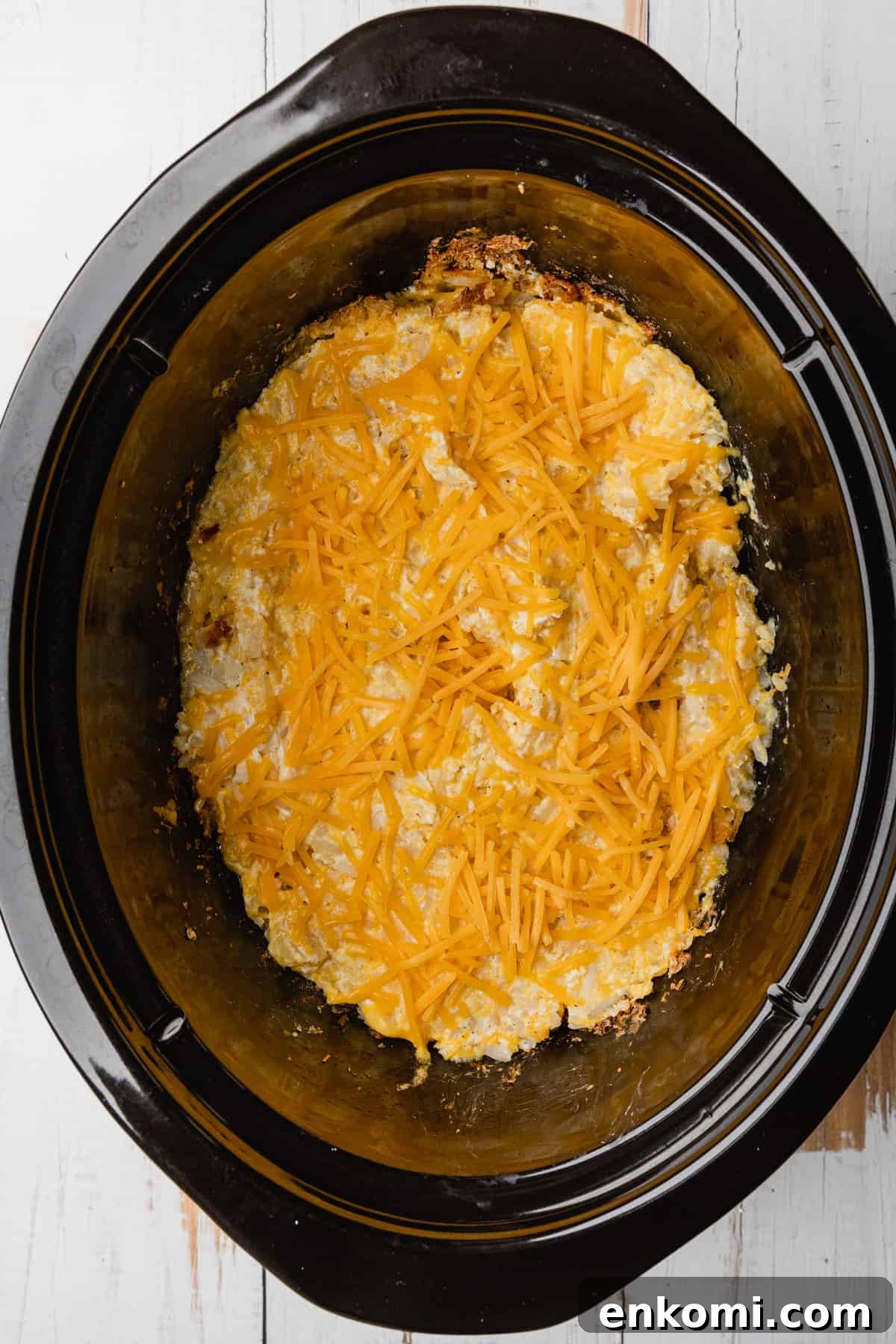 Crockpot Cheesy Hashbrown Casserole Recipe for Slow Cooker 6 Adding cheese to the top of the recipe.
