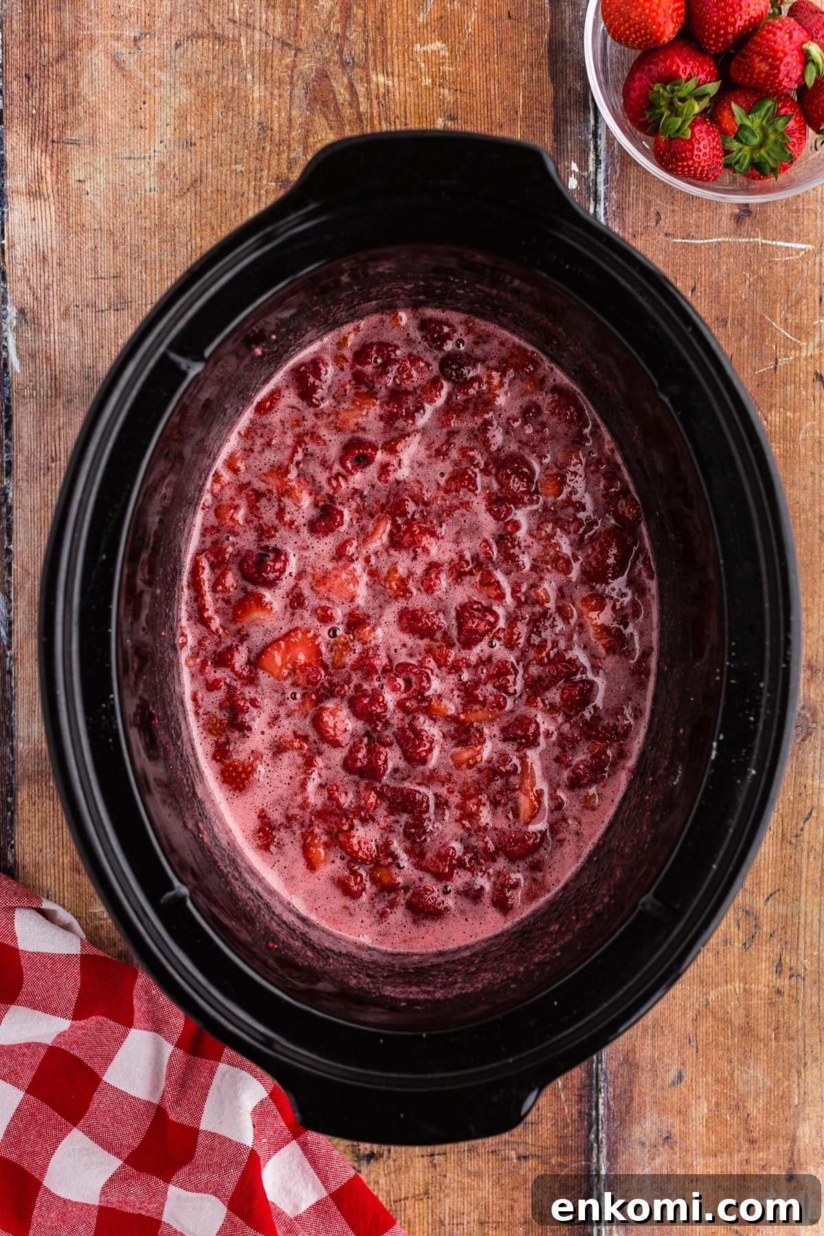 Strawberry raspberry jam cooked and bubbly in a crockpot.