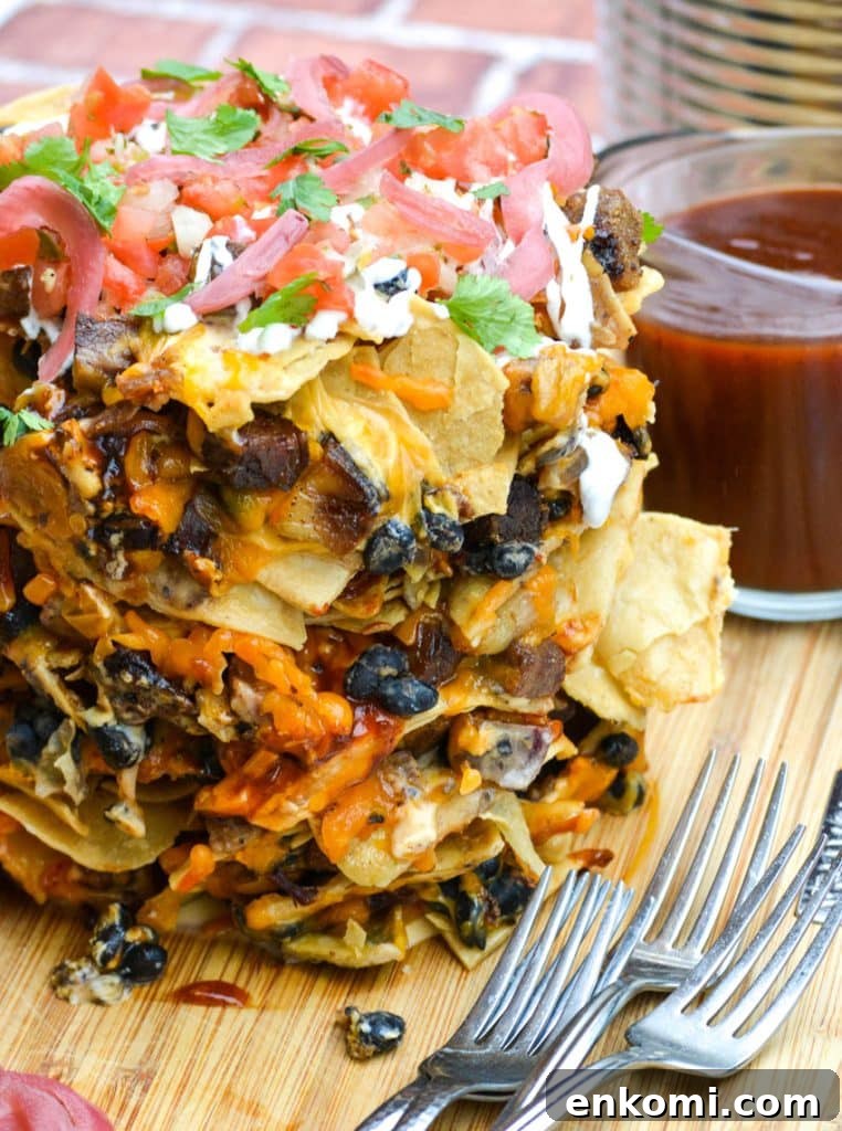 Loaded Nachos: How to Make Trash Can Nachos at Home 2 trash can nachos on a wooden cutting board
