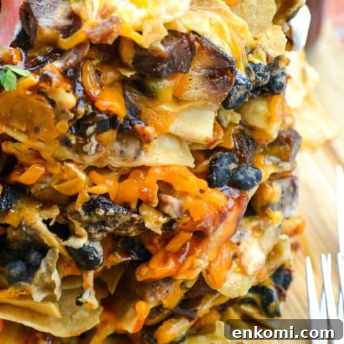 stacked trash can nachos on a wooden cutting board