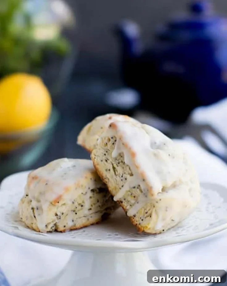 Lemon Ricotta Poppy Seed Scones leand against each other on a pedestal by themerchantbaker.com