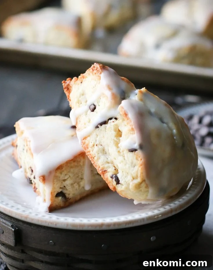 Chocolate Chip Scones leaned against each other on a white plate by themerchantbaker.com