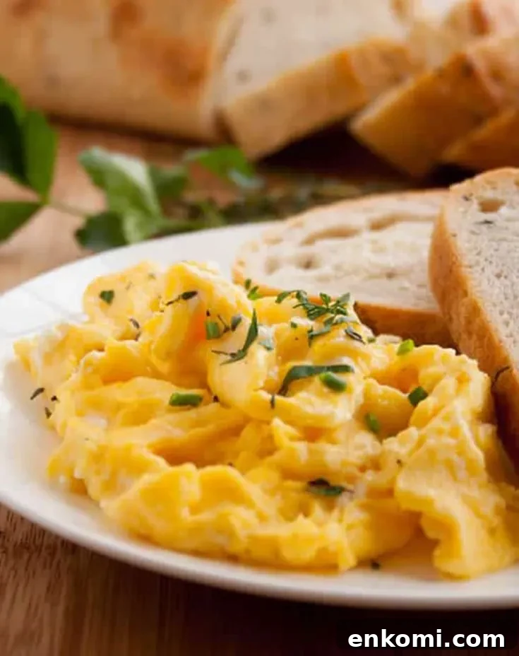 herbed goat cheese scrambled eggs with toast on a plate by themerchantbaker.com