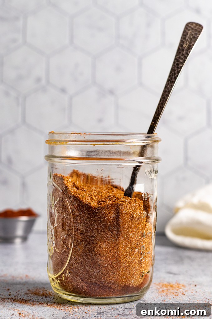 homemade fajita seasoning in a mason jar, with the handle of a spoon sticking out of the mason jar.