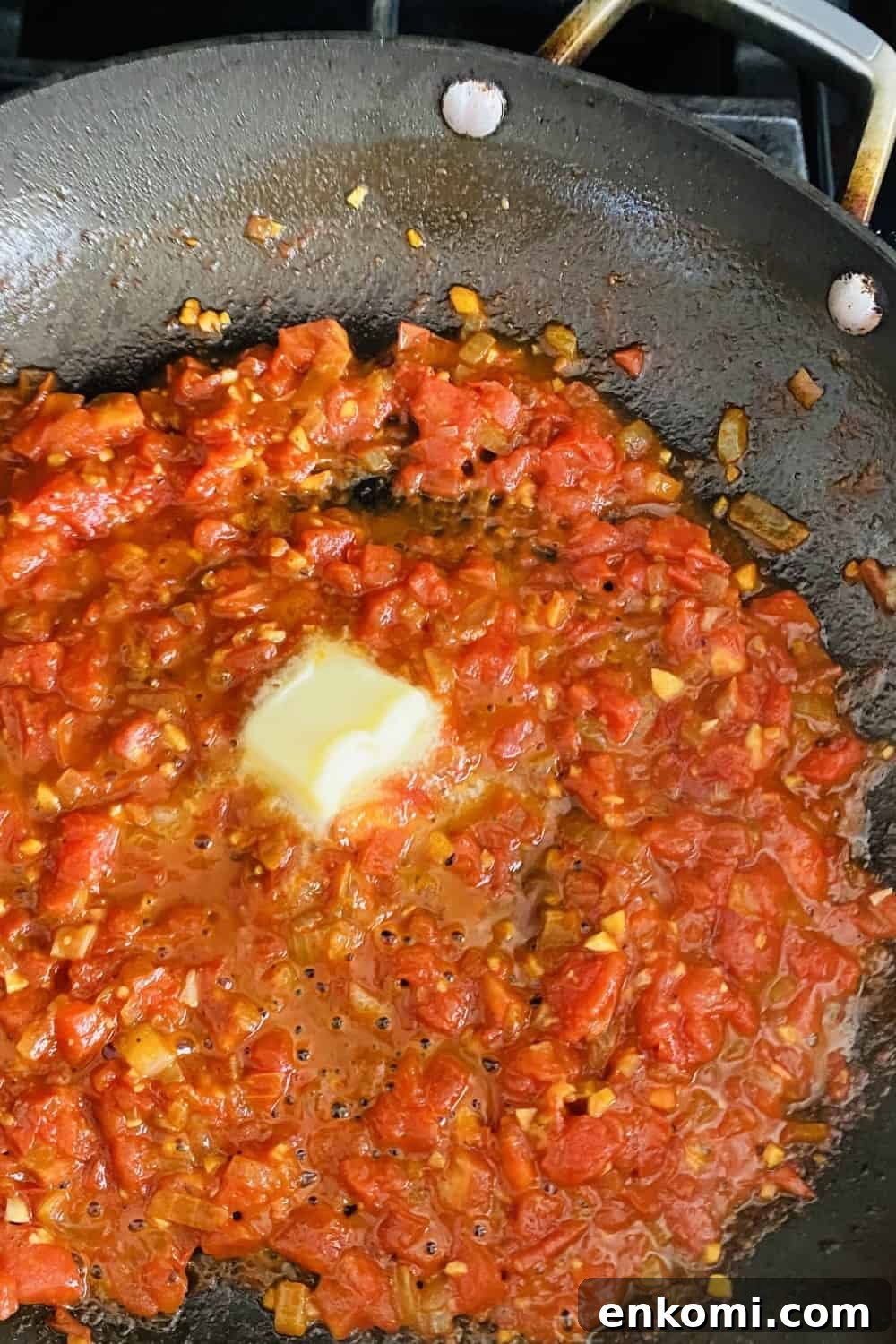 adding butter to tomato pan sauce