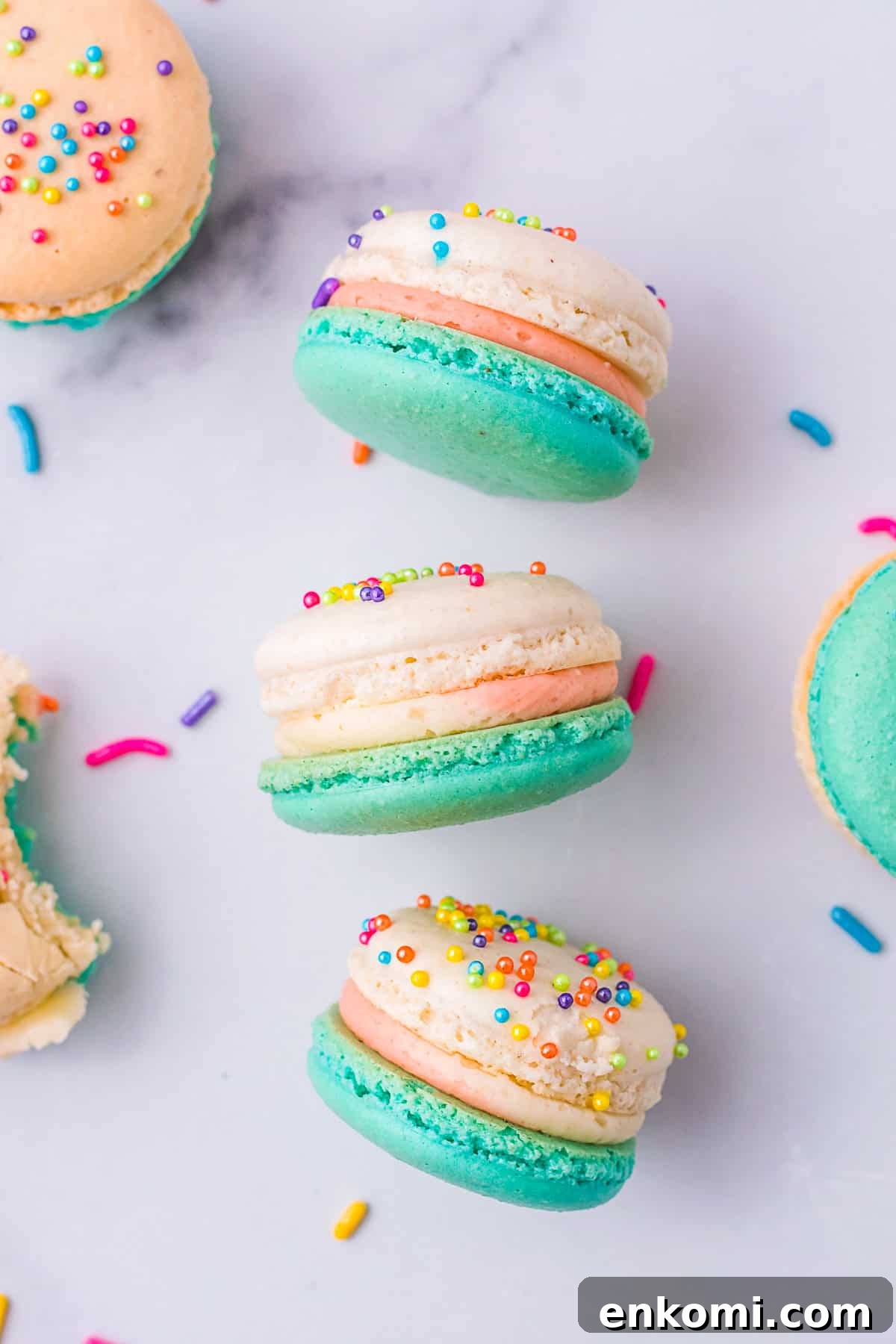 Birthday Cake Macarons laying on a marble board. 