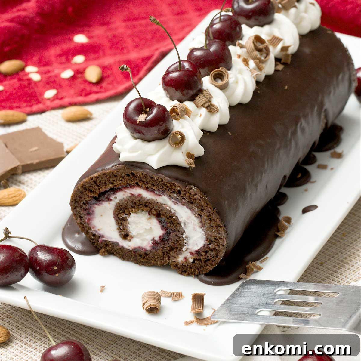 Gluten-Free Levain-Style Chocolate Chip Cookies Recipe 11 A gluten-free chocolate Swiss roll with cherries and whipped cream on top on a cake pan with a spatula.
