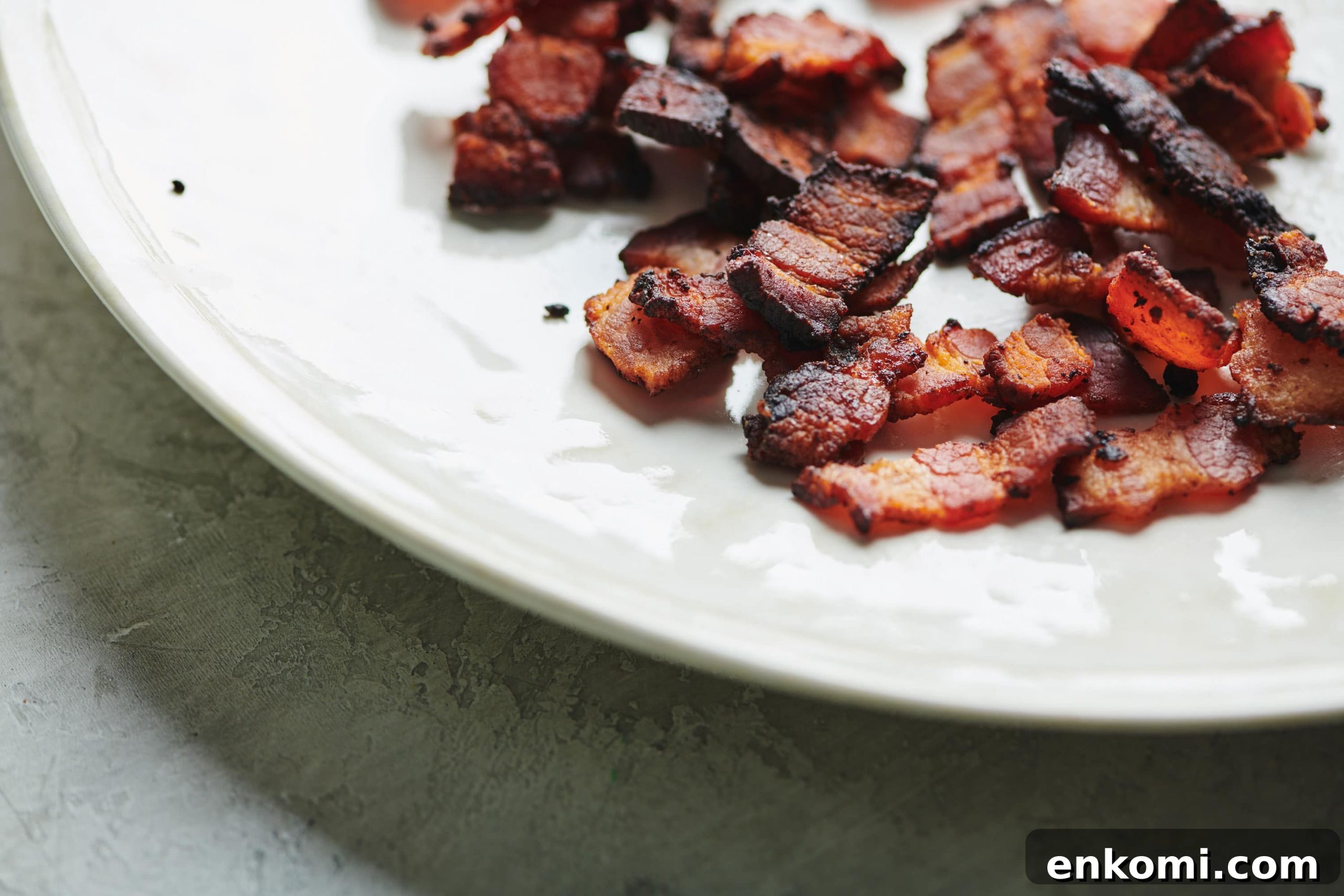 Crispy Bacon Lardons Recipe: Step-by-Step Guide 5 Cooked Bacon Lardons on a white plate.