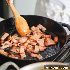 Crispy Bacon Lardons Recipe: Step-by-Step Guide 8 Cooking bacon in pan on stove.