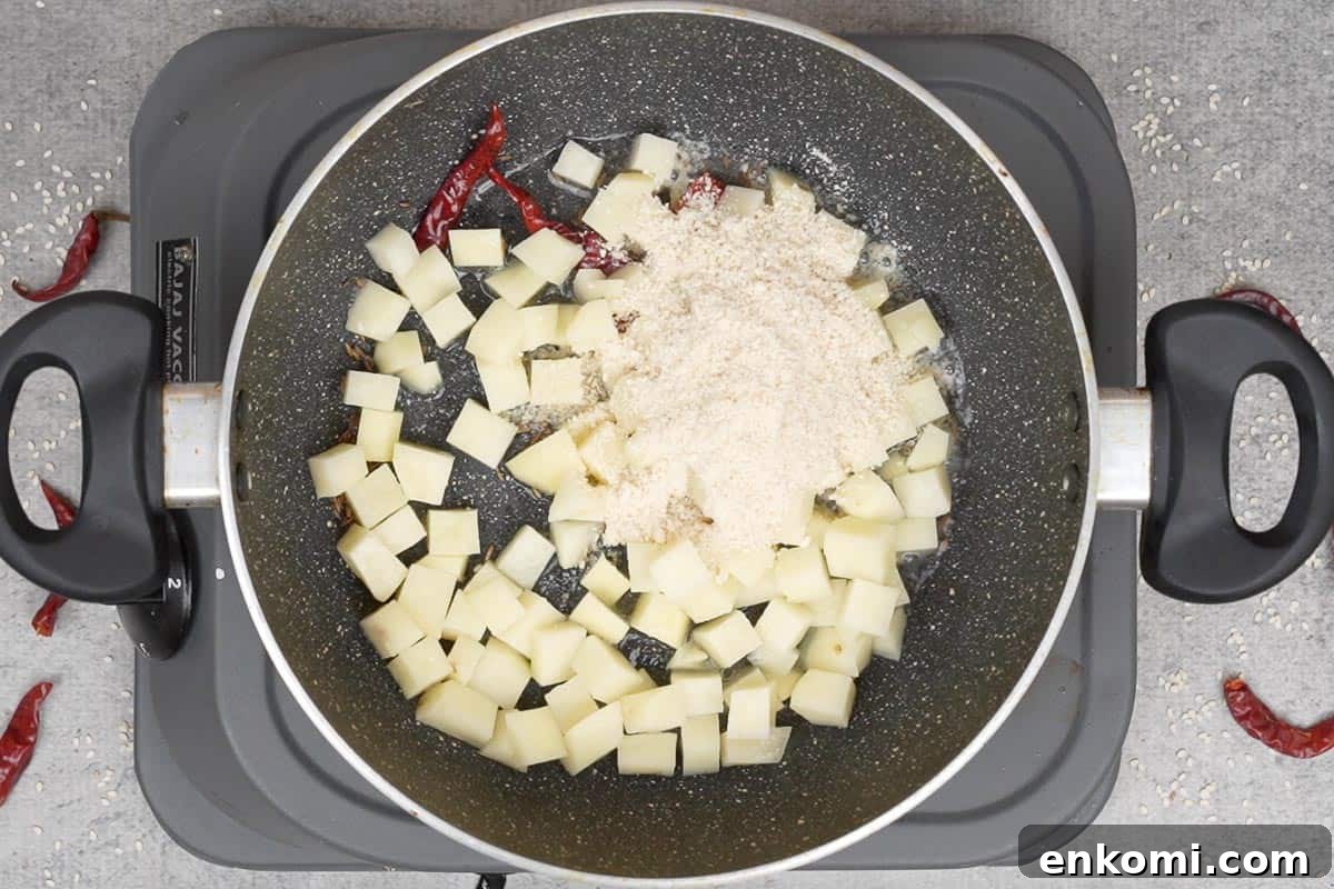 Sesame Potato Stir-Fry (Til Wale Aloo) Recipe 7 Potatoes and sesame powder added to the pan.