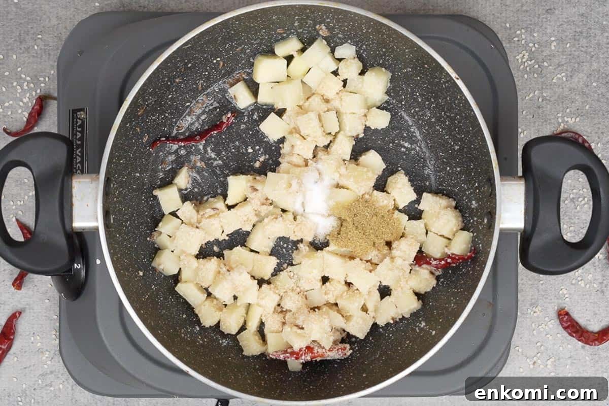 Sesame Potato Stir-Fry (Til Wale Aloo) Recipe 8 Coriander powder and salt added to the pan.