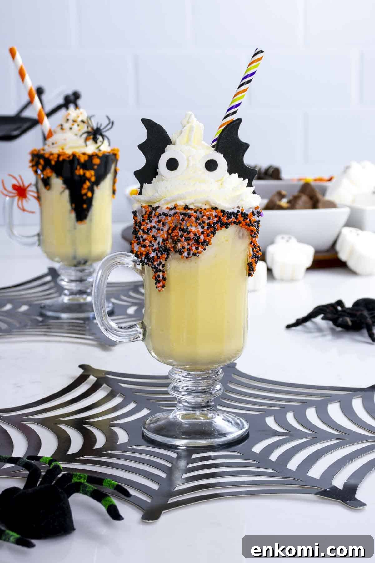 Halloween Milkshake Bar Ideas for Kids: Spooky Flavors & Toppings 2 Kids Halloween milkshake on table with bat ears, wings, and a straw.