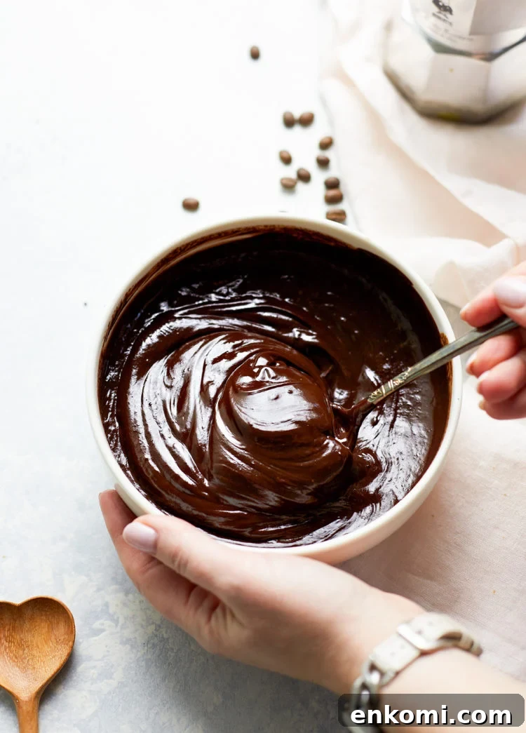 woman stirring a bowl of chocolate ganache