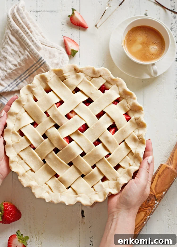 woman holding a pie with a lattice pie crust