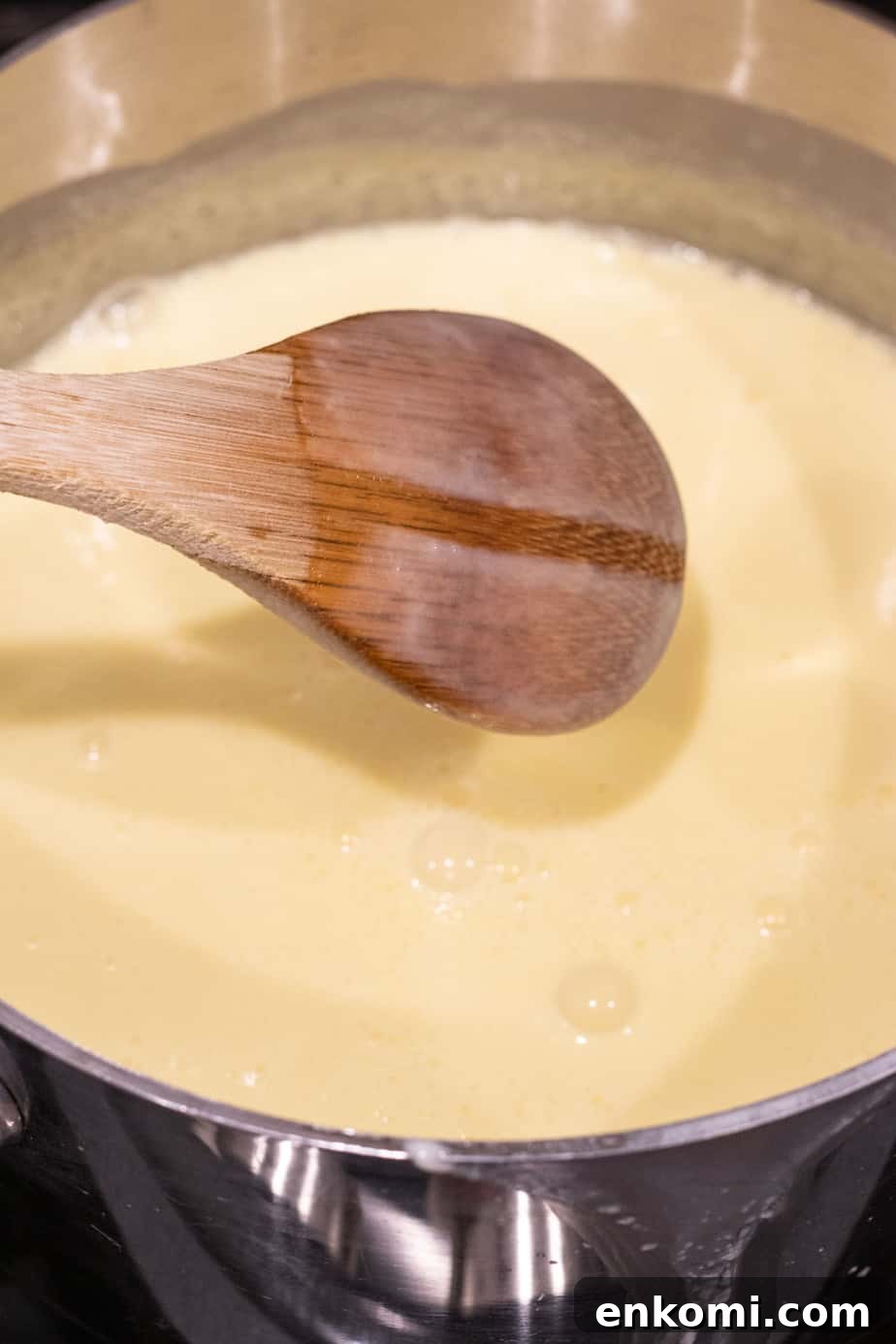 Salted Caramel Chocolate Budino Recipe for Decadent Dessert 4 custard in saucepan with wooden spoon coated in custard