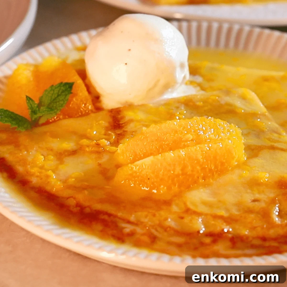 homemade crepes suzette on a plate with vanilla ice cream
