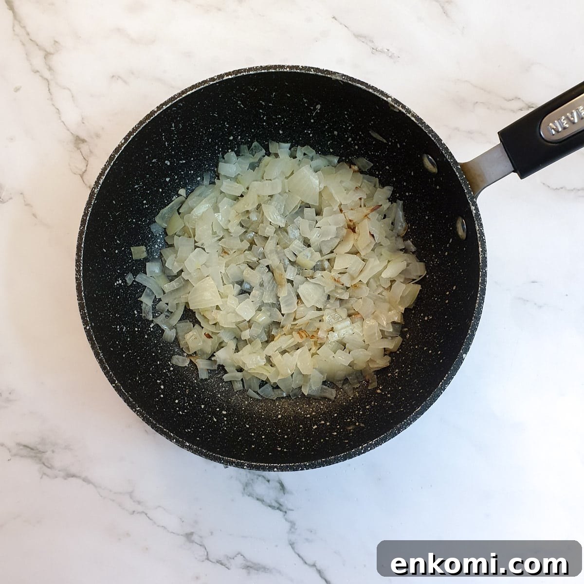 Chopped onions frying in a pan.