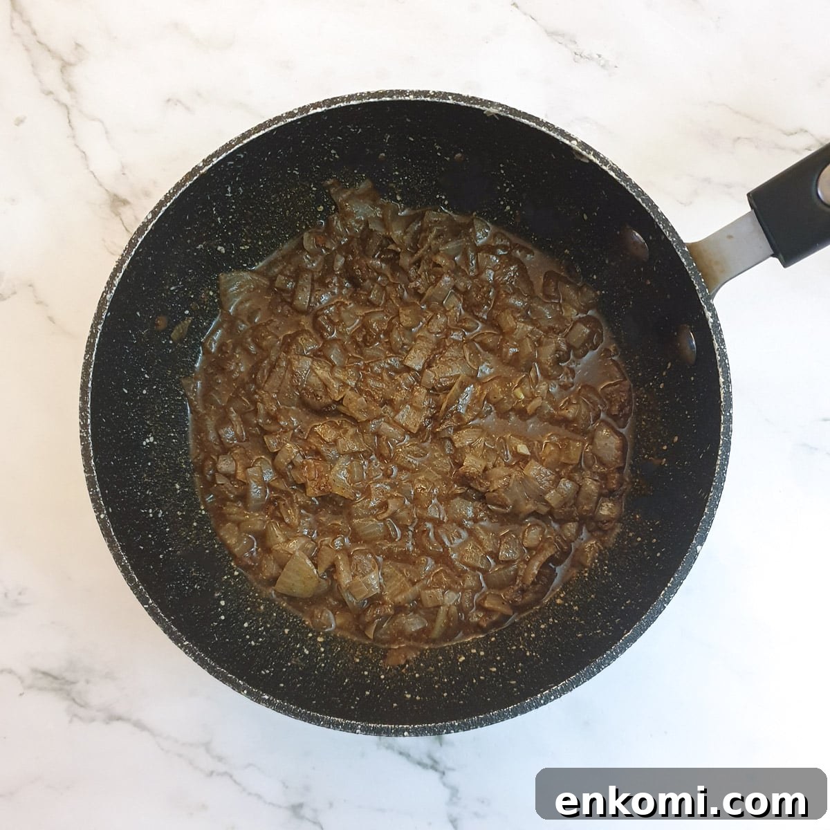Canned sweetcorn liquid added to onions  and spices in a frying pan.