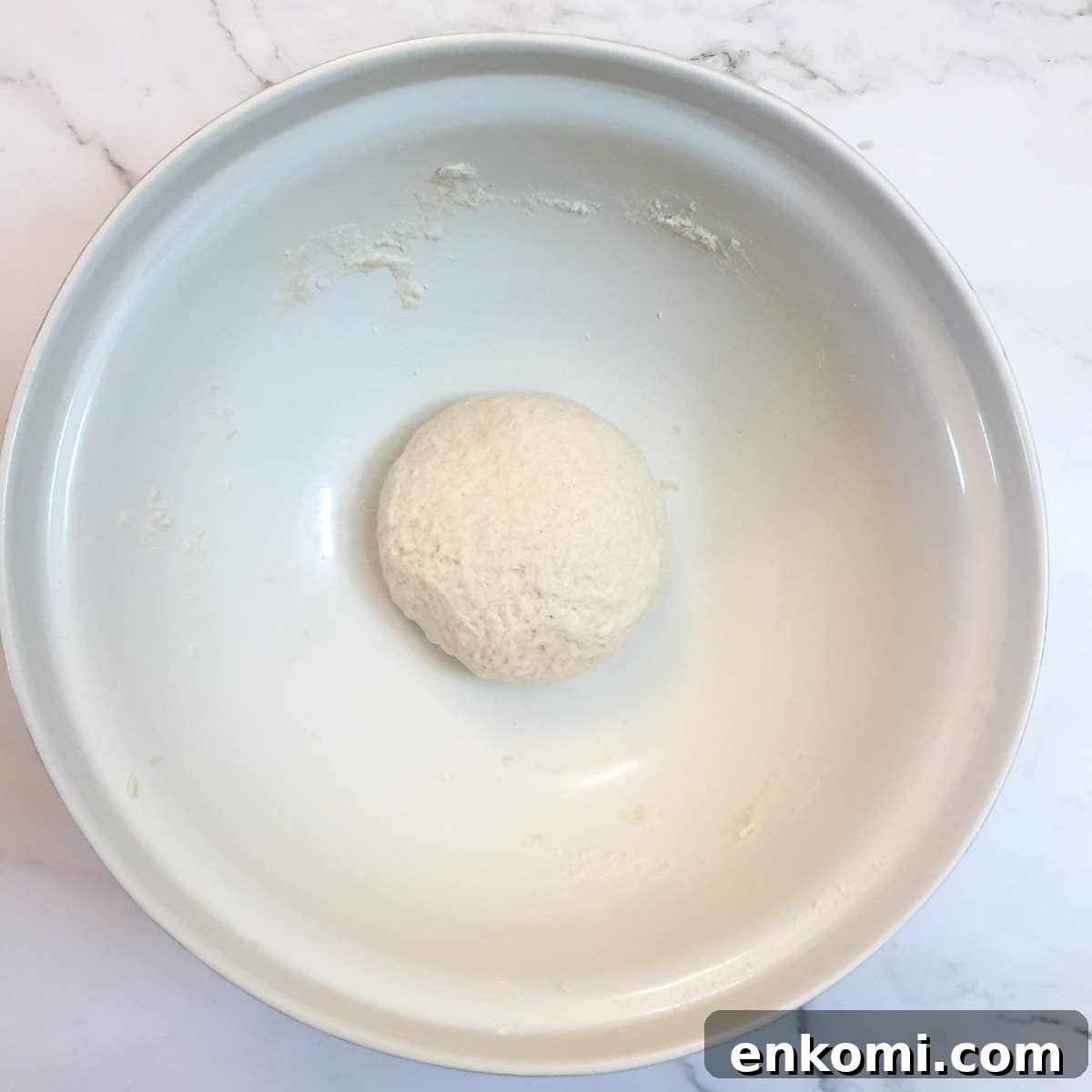 A ball of dough in a mixing bowl.