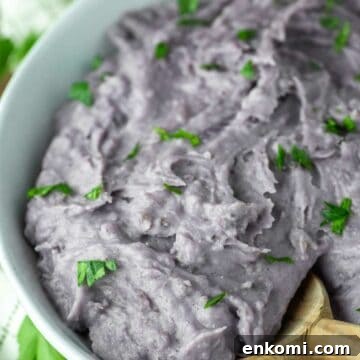 wooden spoon dipped in bowl of purple mashed potatoes