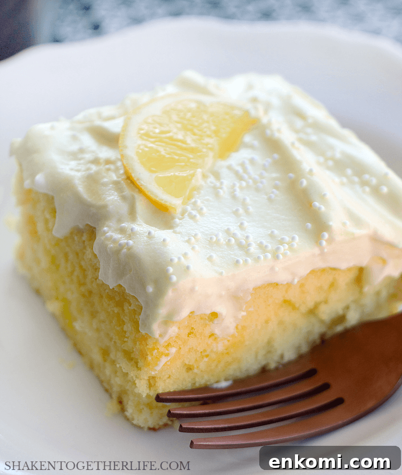 15 Irresistible Poke Cake Recipes to Try Tonight 8 lemon poke cake topped with lemon slice on white plate